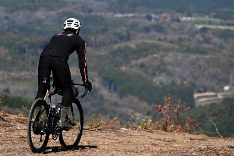グラベルロードの丘を走るサイクリスト