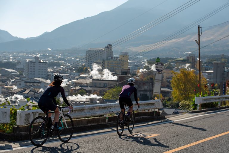 鉄輪温泉の湯けむりを眺めながら走るサイクリスト