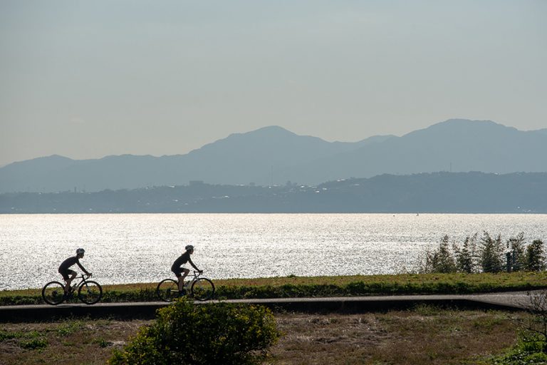 日出町の別府湾を背走るサイクリスト