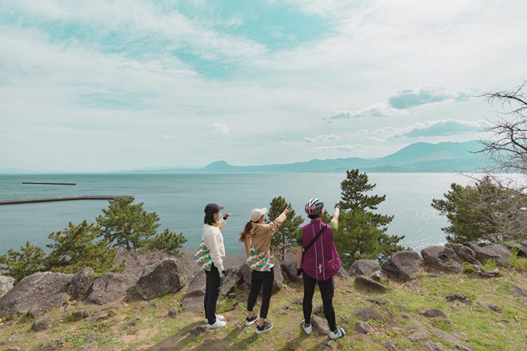 別府湾を望む城跡の上に立つサイクリスト